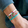 a person wearing a bracelet with flowers on it
