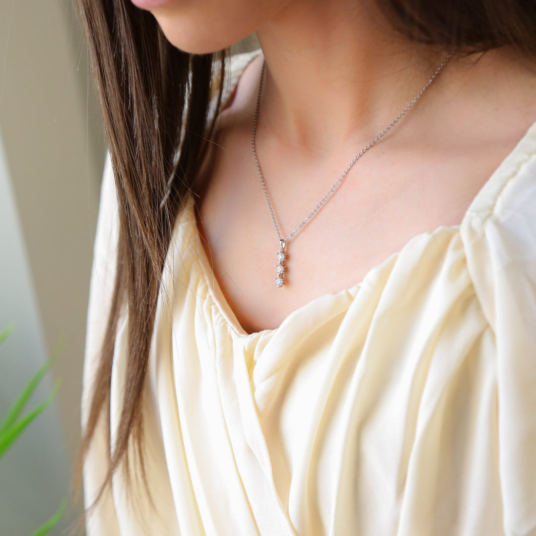 a woman wearing a necklace with a cross on it