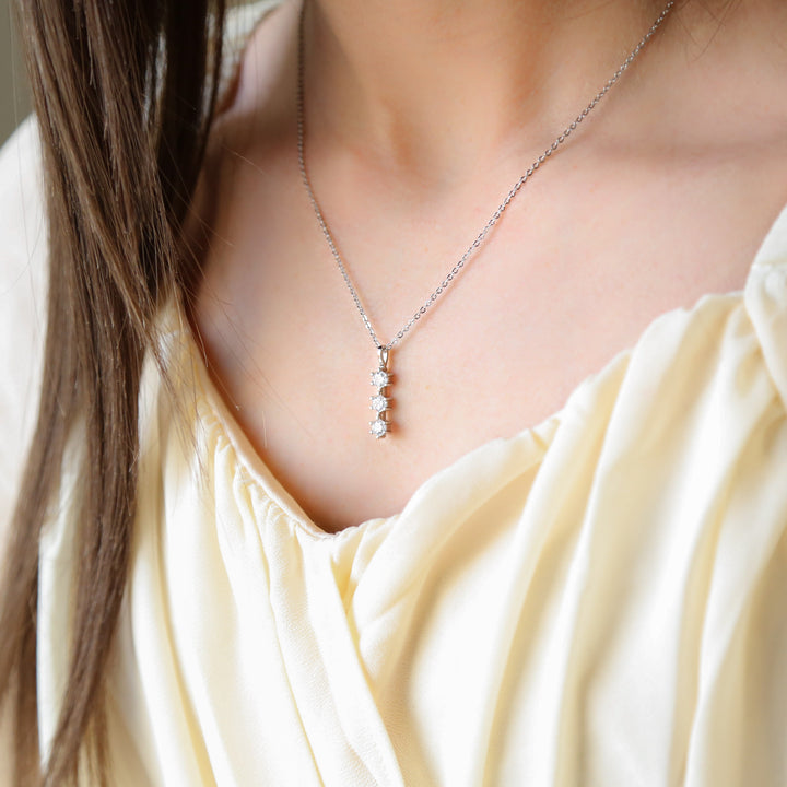 a woman wearing a white dress and a silver necklace