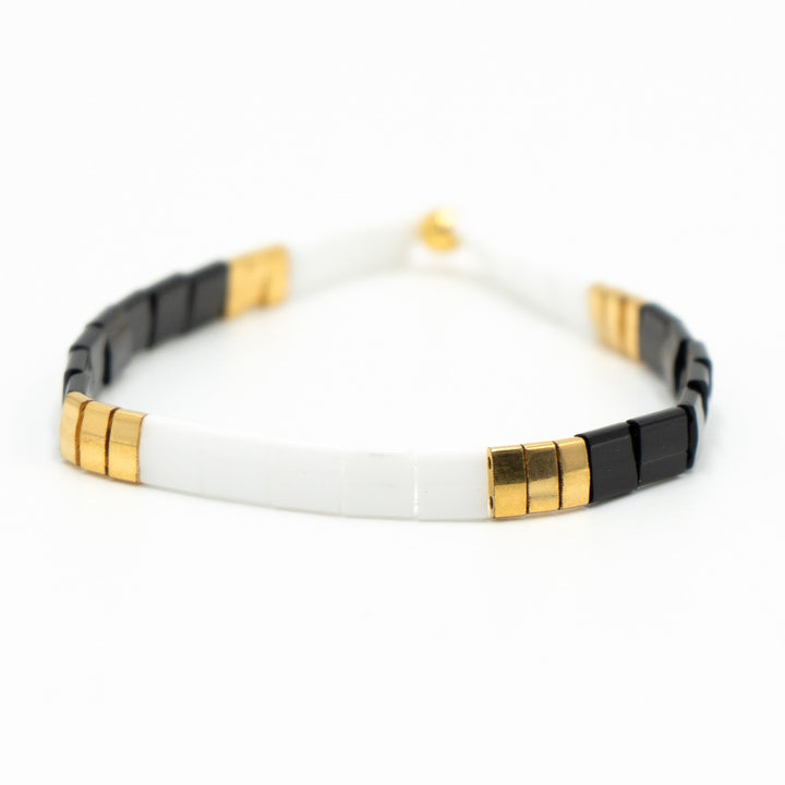 a black and white bracelet with gold accents