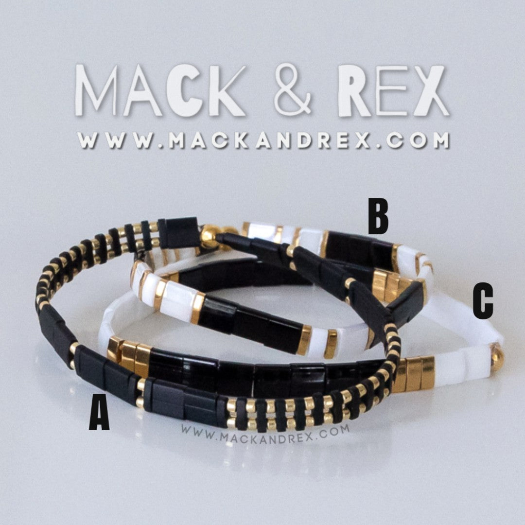 a couple of black and white bracelets with gold accents