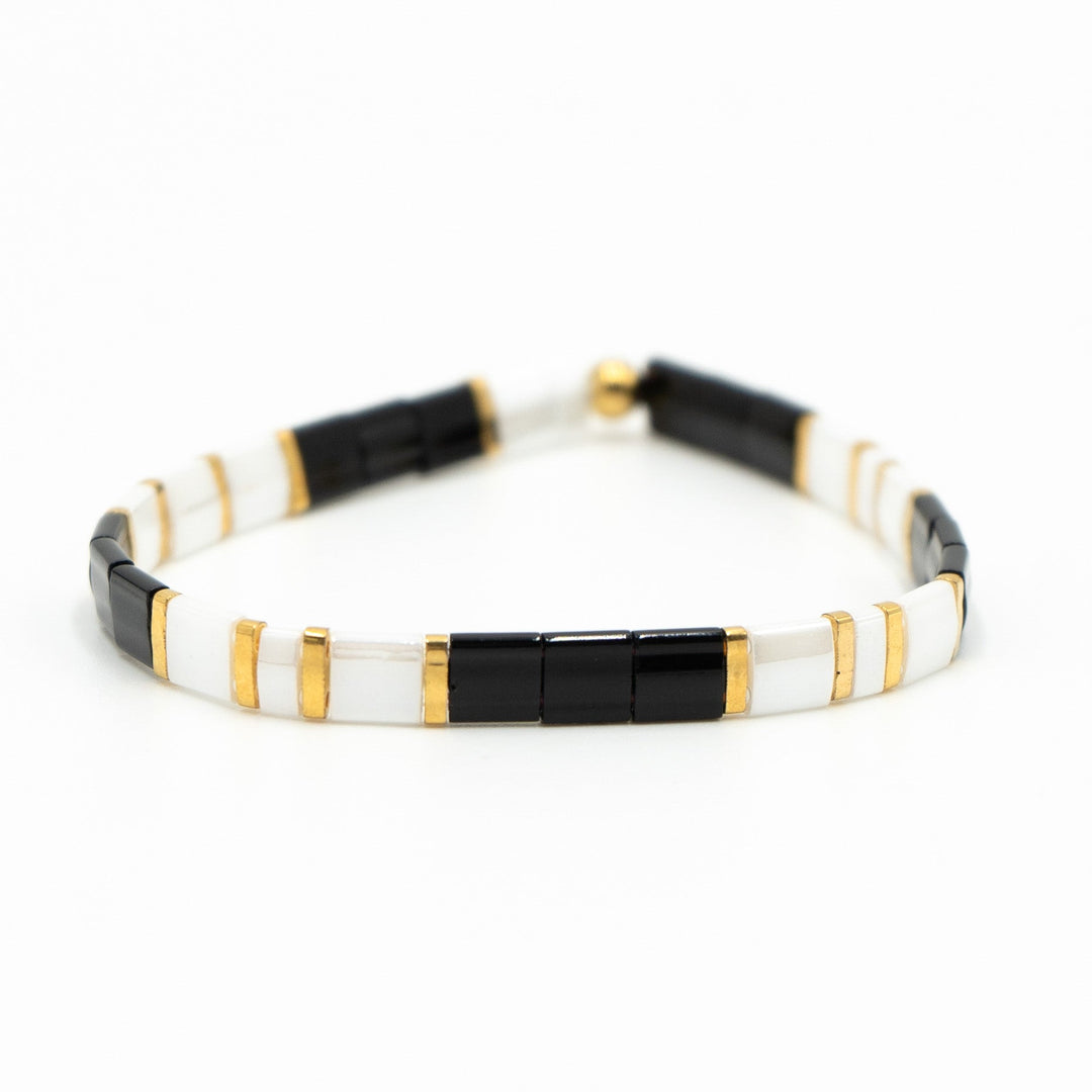 a black and white bracelet with gold accents