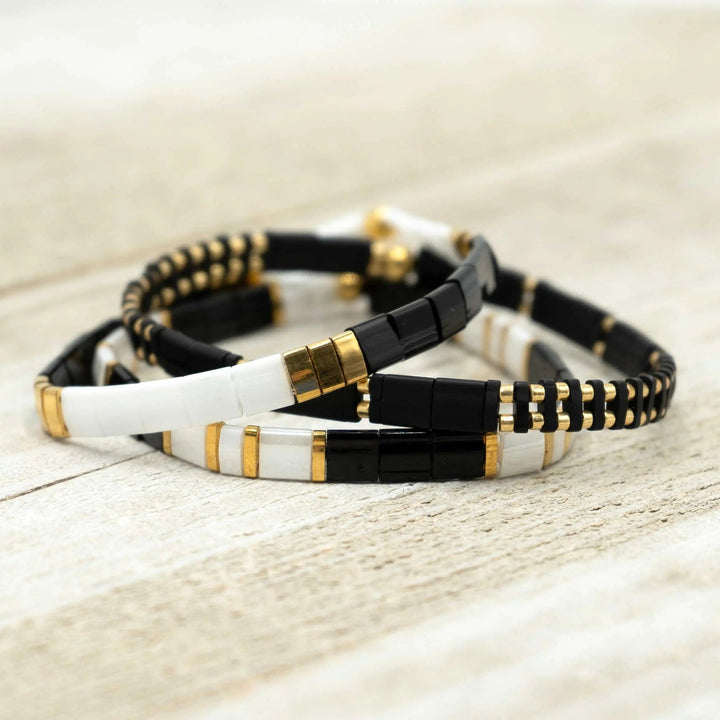 a couple of bracelets sitting on top of a wooden table