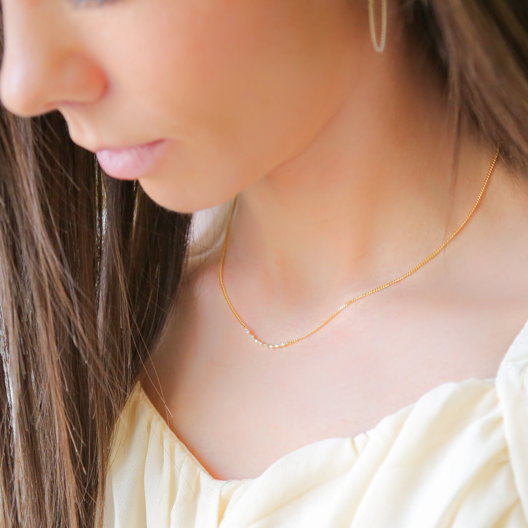 a close up of a woman wearing a necklace