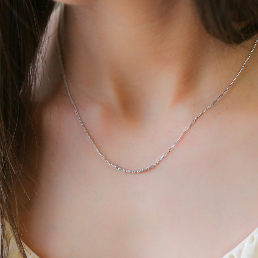 a close up of a woman wearing a necklace