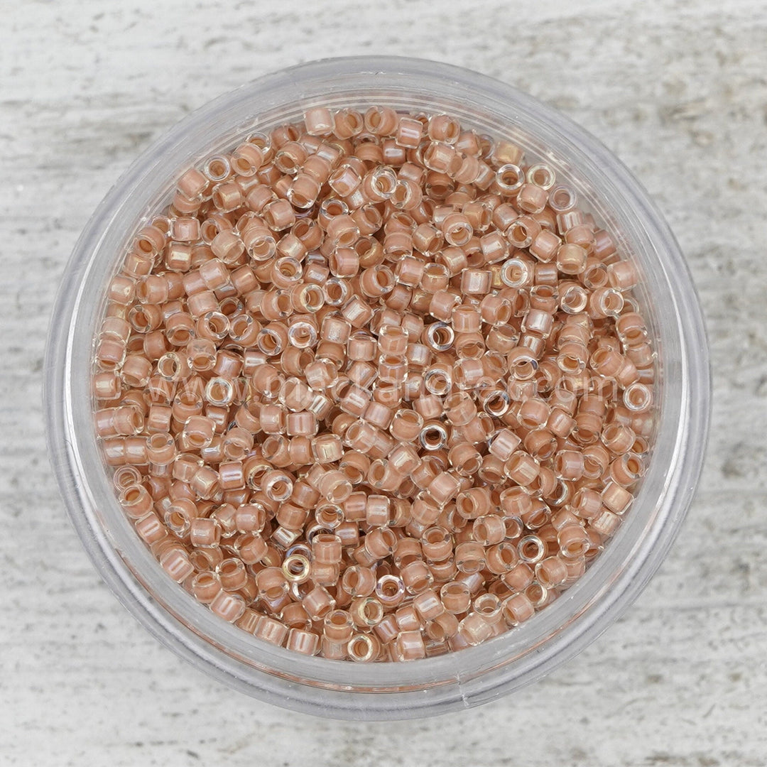 a bowl filled with brown seed beads on top of a table