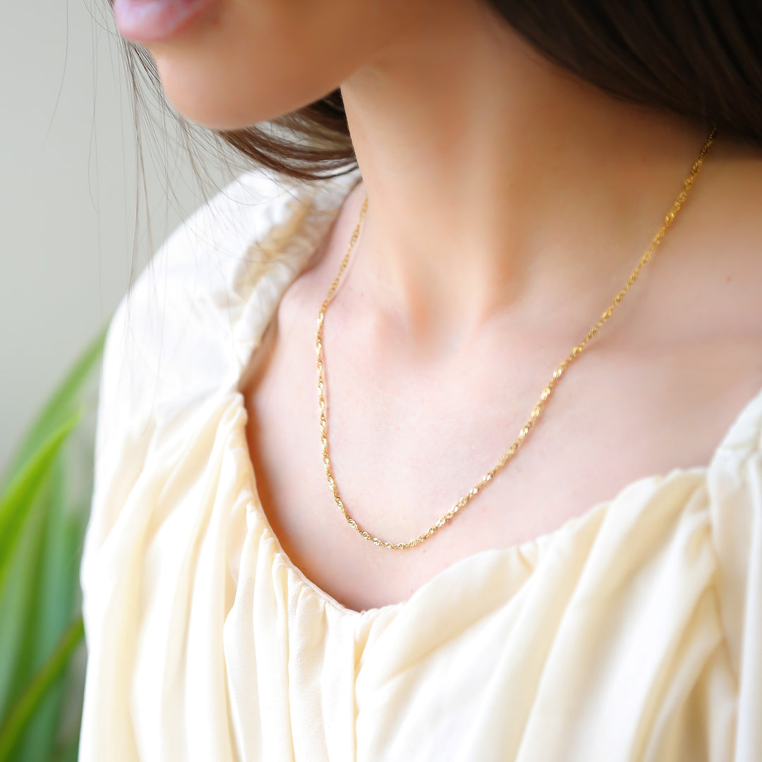 a close up of a woman wearing a necklace