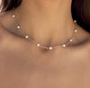 a close up of a woman wearing a necklace with pearls