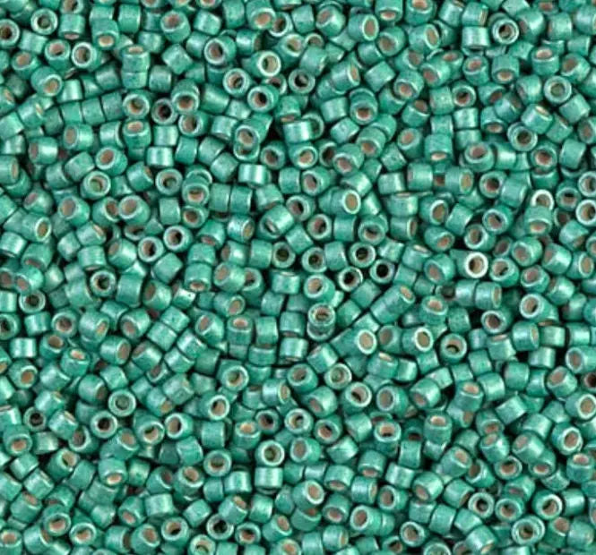 a close up of a bunch of green seed beads