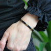 a person wearing a black and gold bracelet