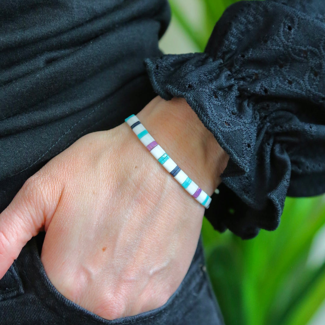 a person wearing a bracelet with a white and blue stripe