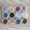 a group of small containers filled with different colored beads