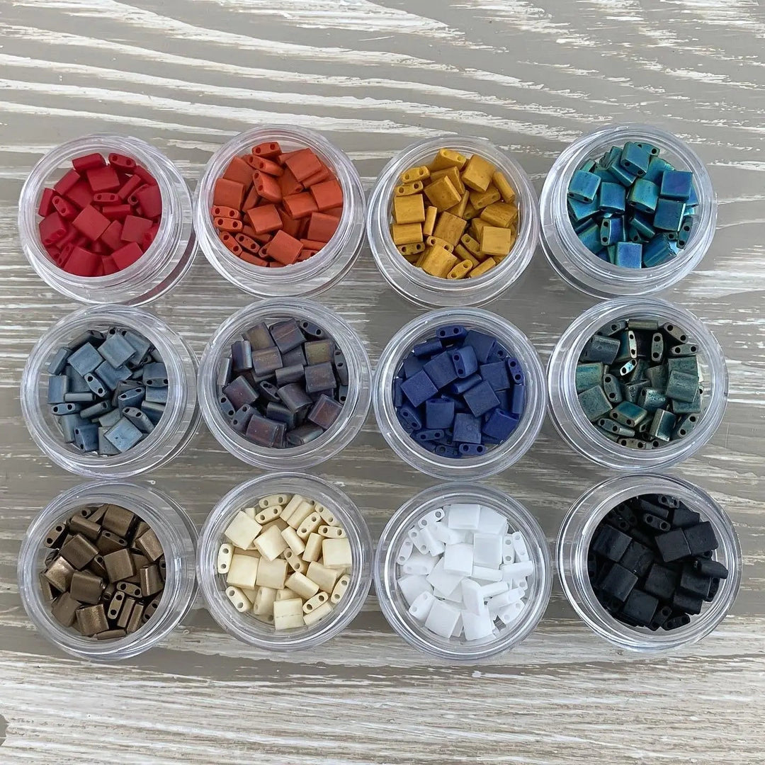 a group of small containers filled with different colored beads