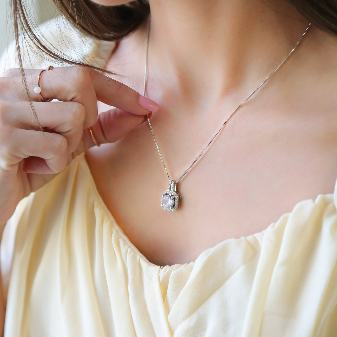 a woman in a yellow dress holding onto a necklace