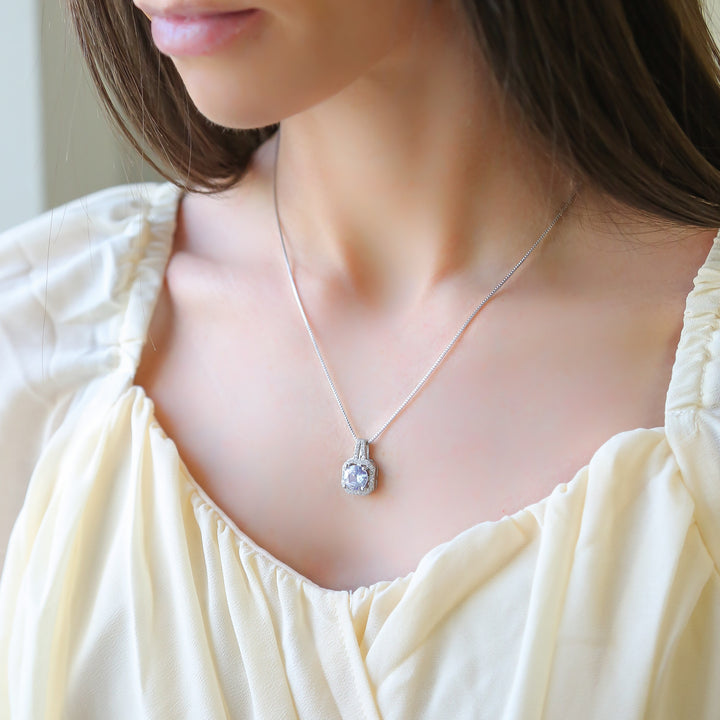 a woman wearing a white dress and a silver necklace