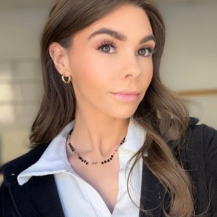 a woman with long hair wearing a white shirt and black jacket