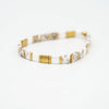 a white and gold bracelet on a white background
