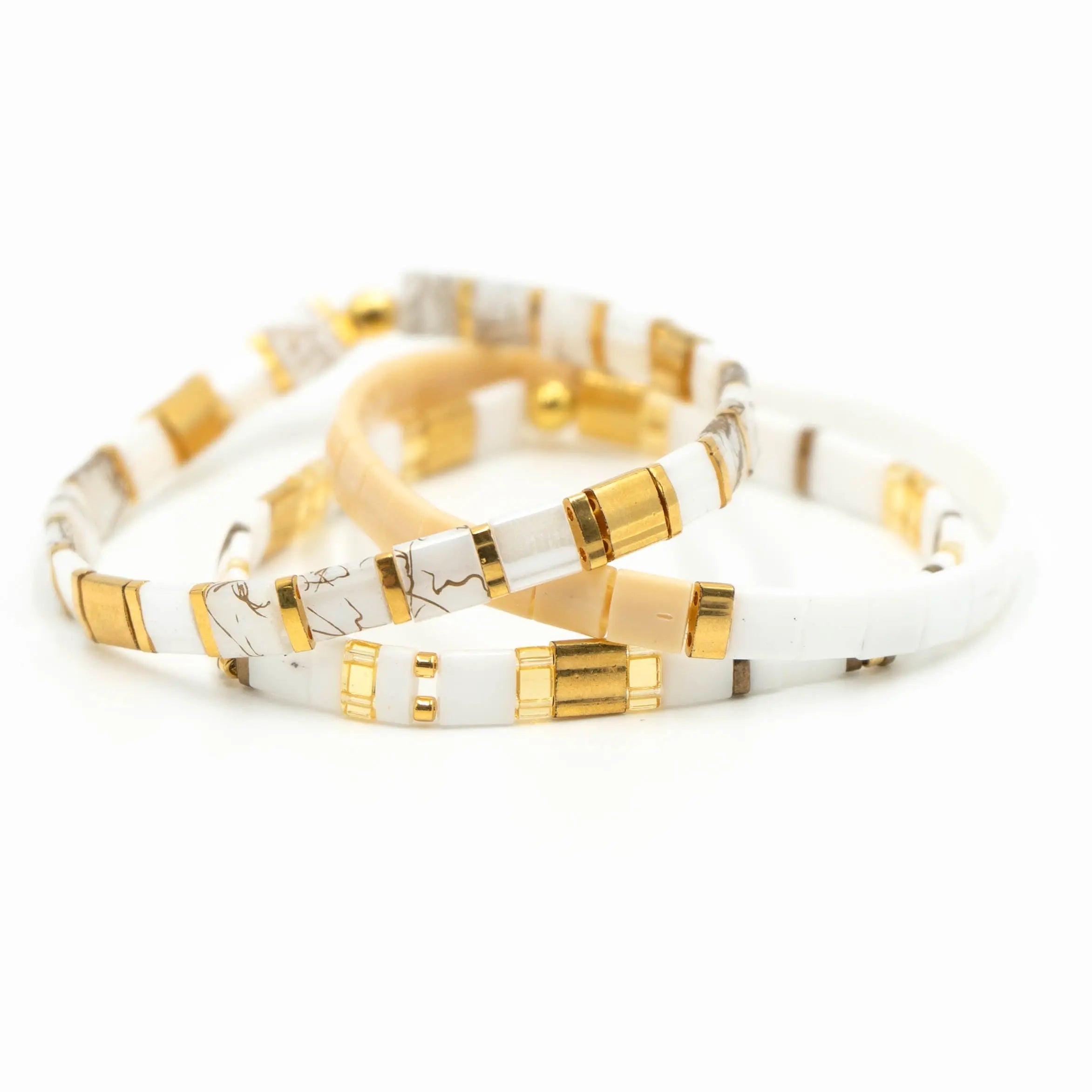 three white and gold bracelets on a white background