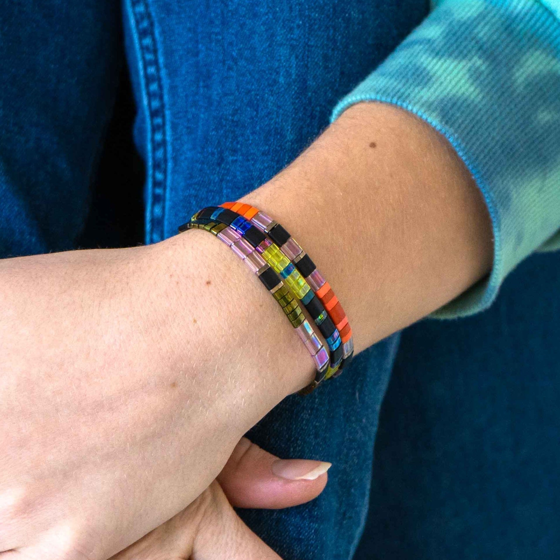 a woman wearing a colorful bracelet on her wrist
