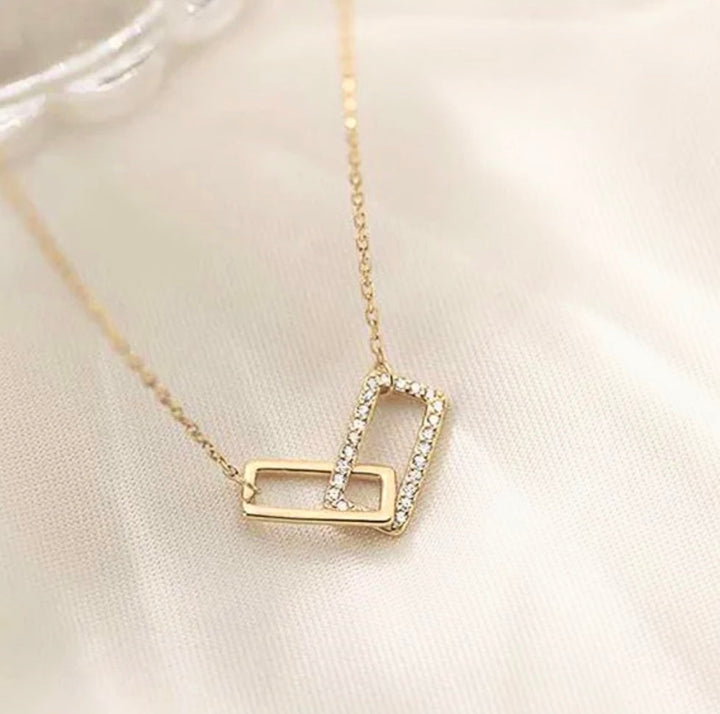 a gold necklace with a diamond letter on it