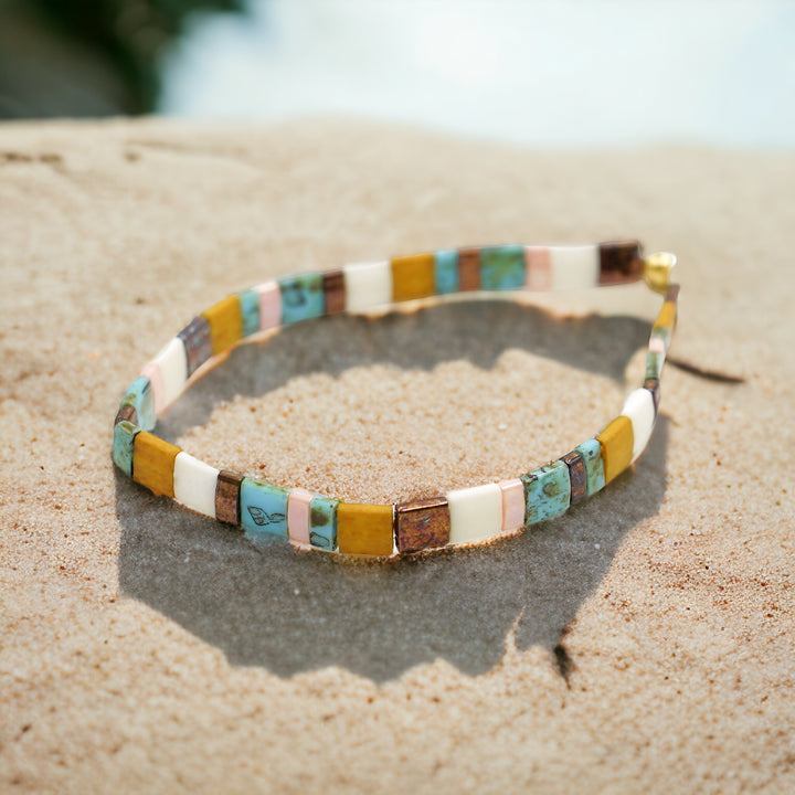 Colorful beaded headband on sand with a blurred natural background