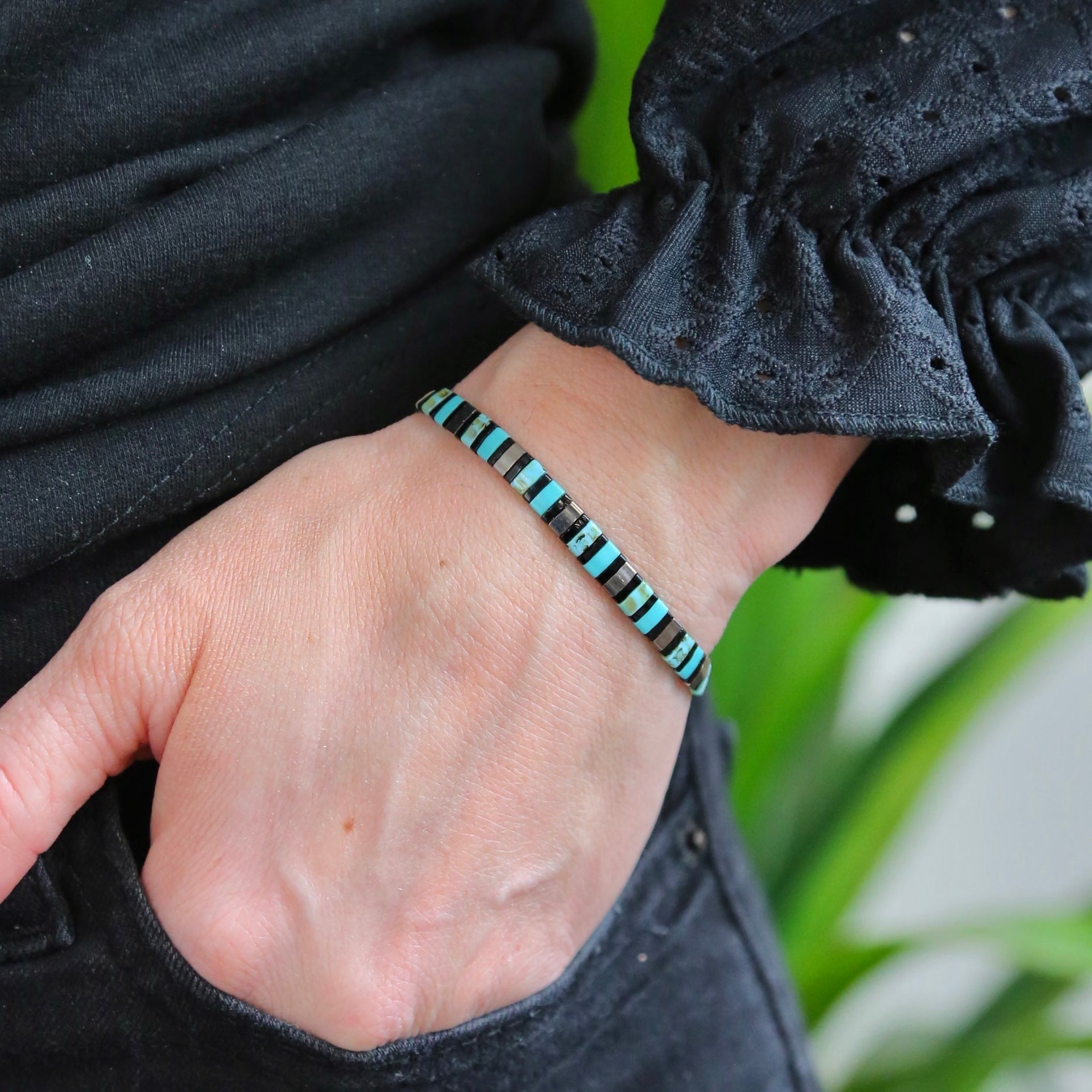 a person wearing a bracelet with a turquoise bead