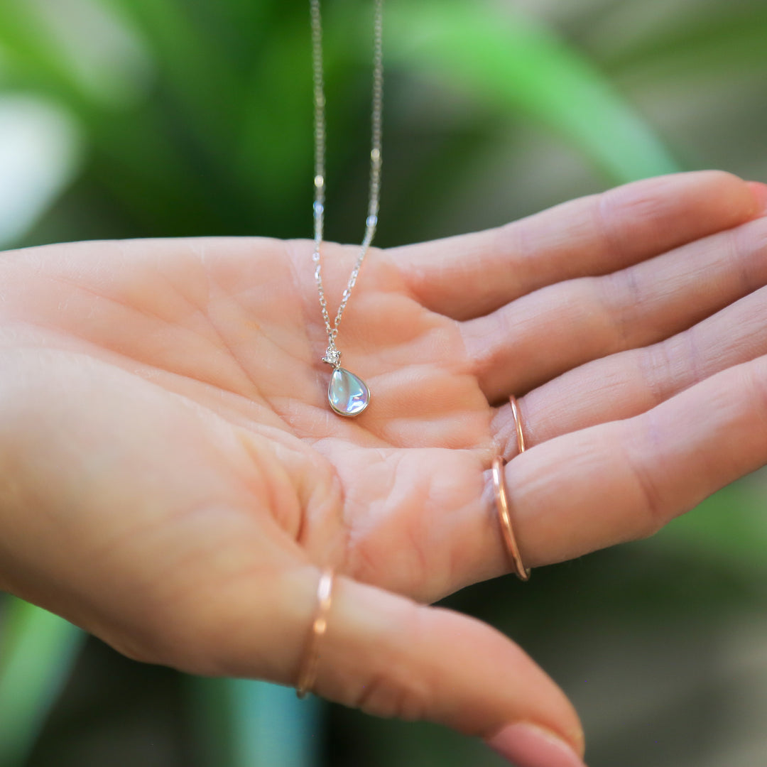 a person holding a piece of jewelry in their hand