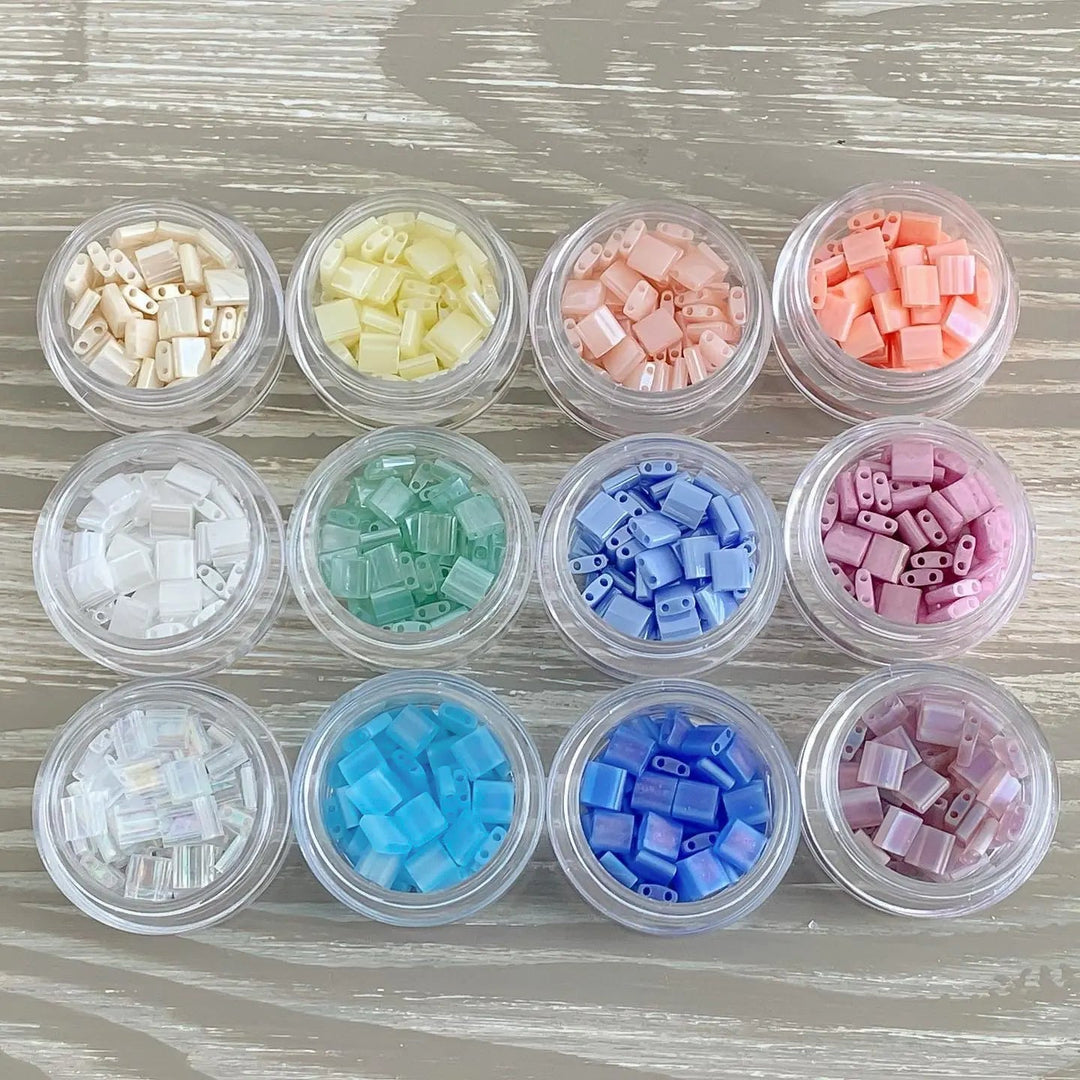 a close up of many different colored beads in a container