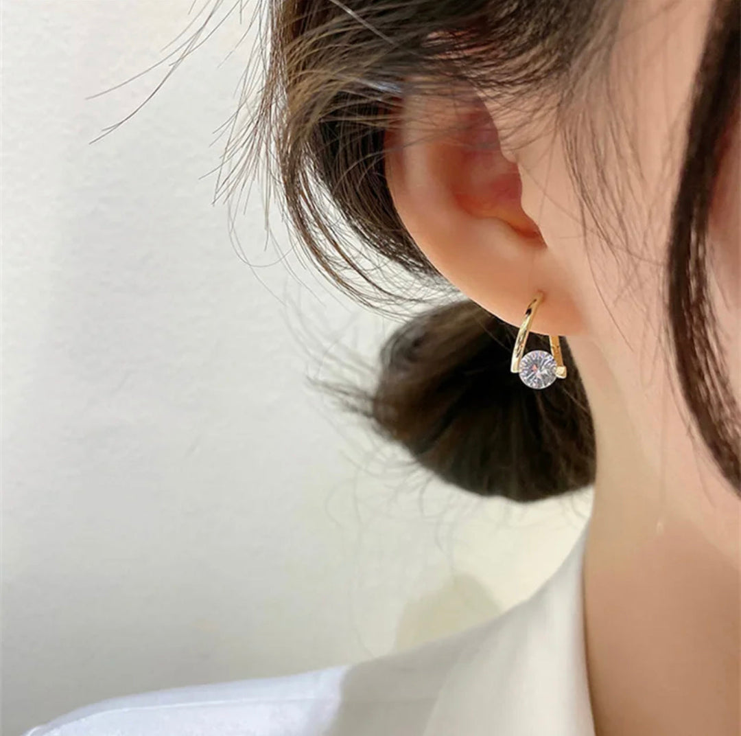 a close up of a person wearing a pair of earrings