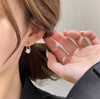 a woman wearing a pair of diamond earrings