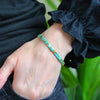 a woman's hand wearing a bracelet with turquoise beads