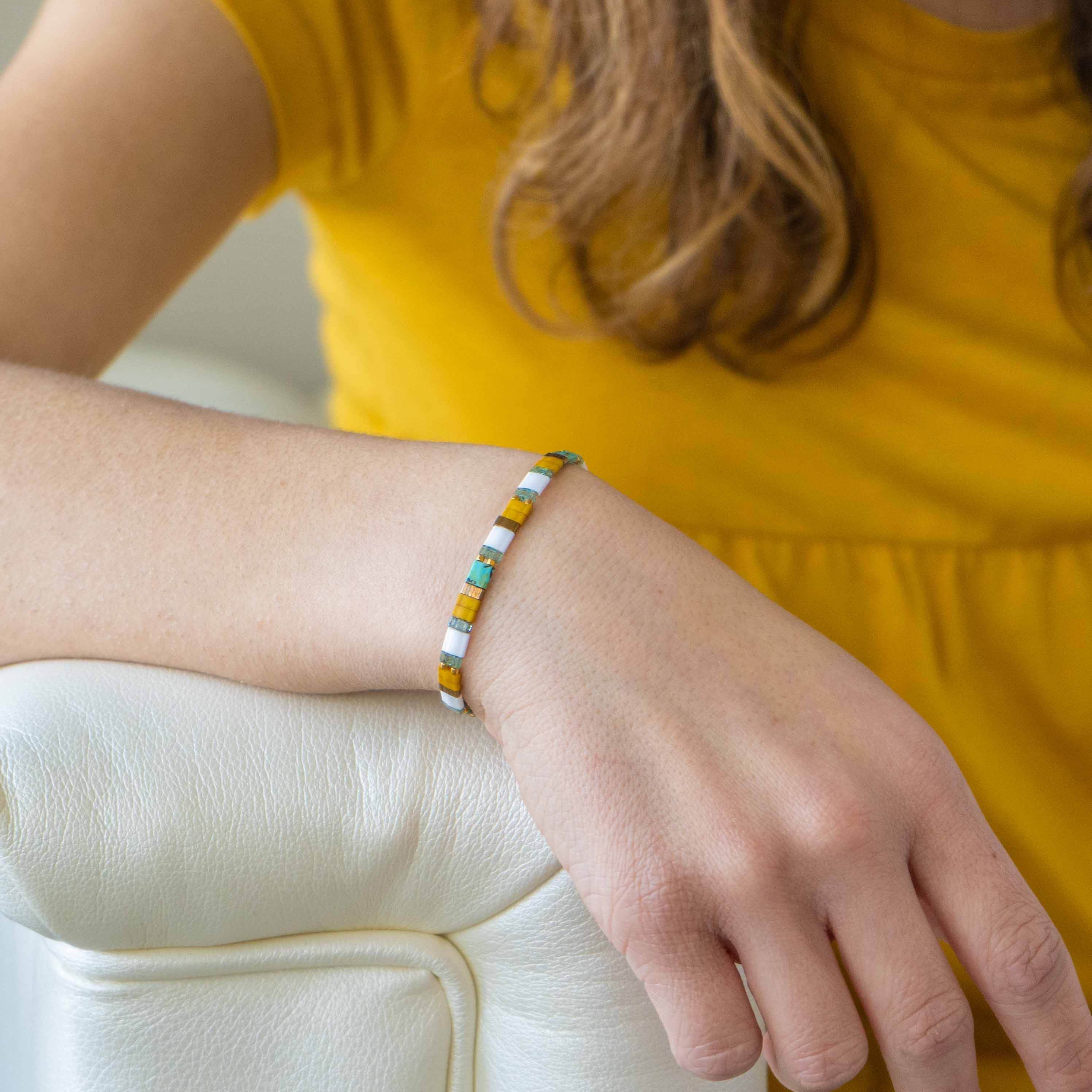 a woman wearing a yellow shirt and a bracelet