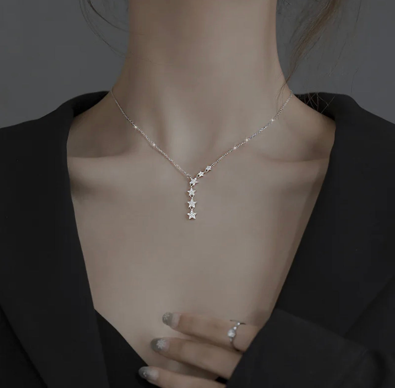 a woman wearing a necklace with stars on it