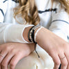 a woman wearing a white shirt and a bracelet