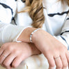 a woman wearing a white shirt and a silver bracelet