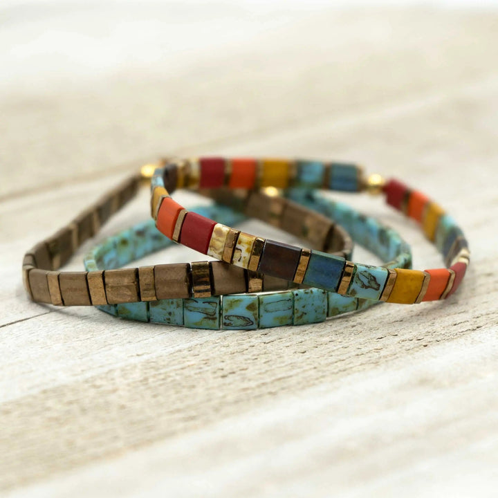 a couple of bracelets sitting on top of a wooden table