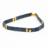 a blue and gold bracelet on a white background