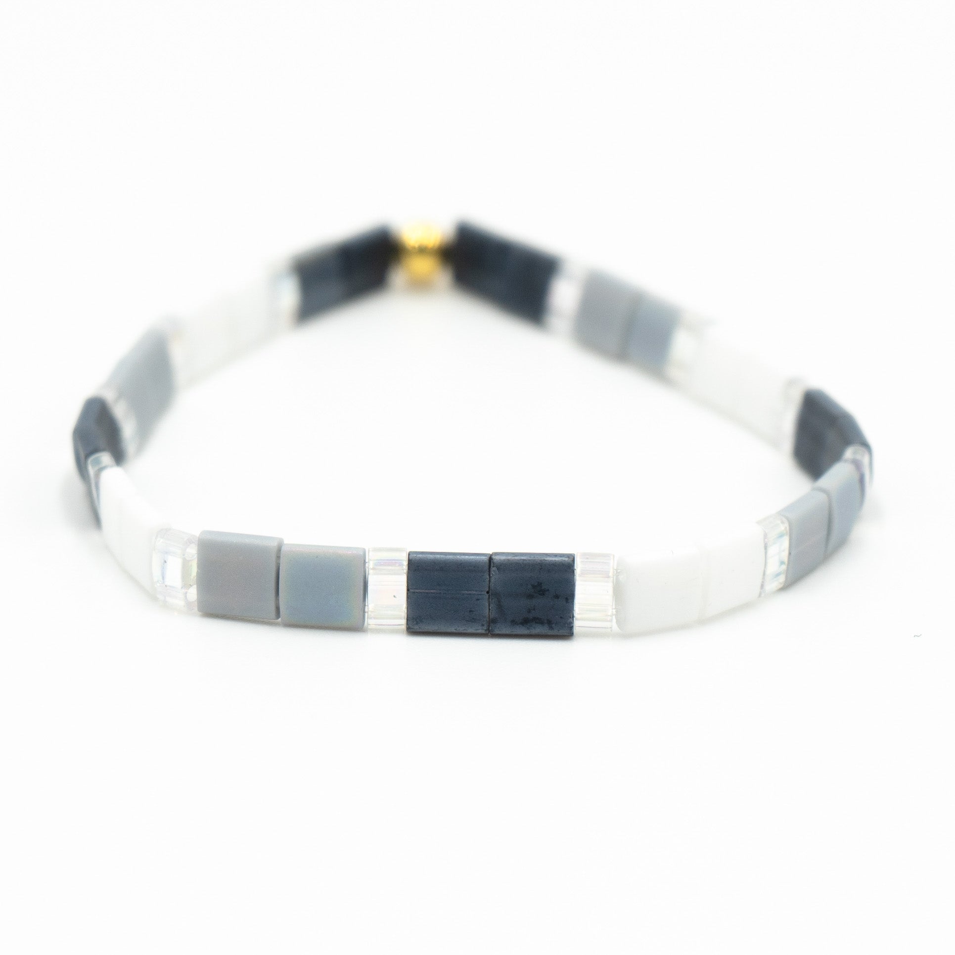 a black and white bracelet with a gold clasp