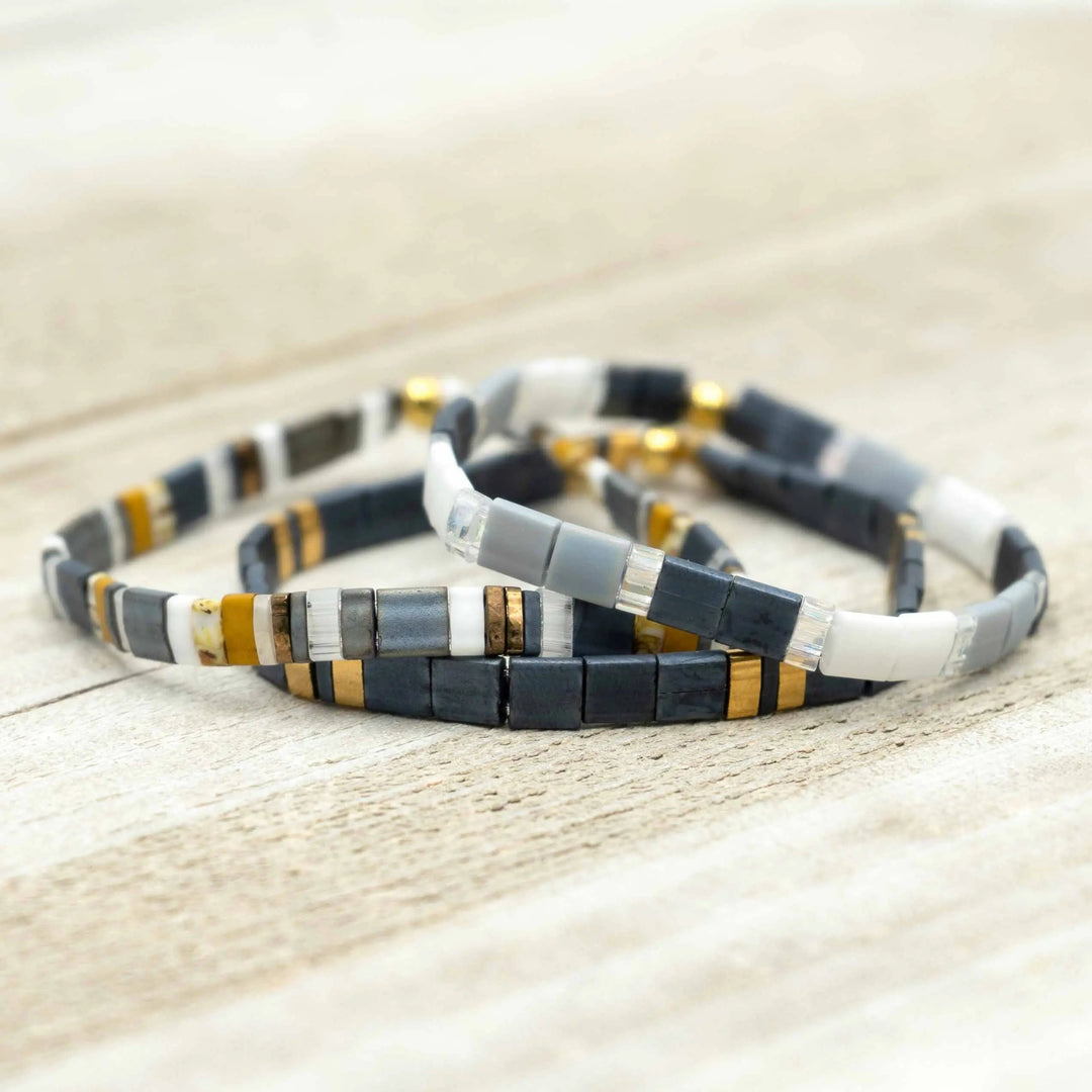 a couple of bracelets sitting on top of a wooden table