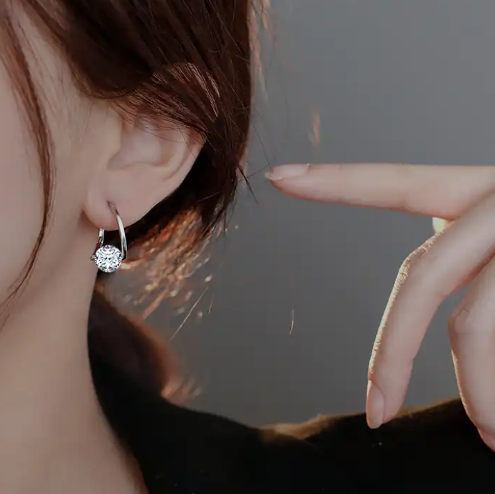 a close up of a person wearing a pair of earrings