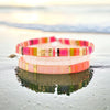 a couple of bracelets sitting on top of a beach
