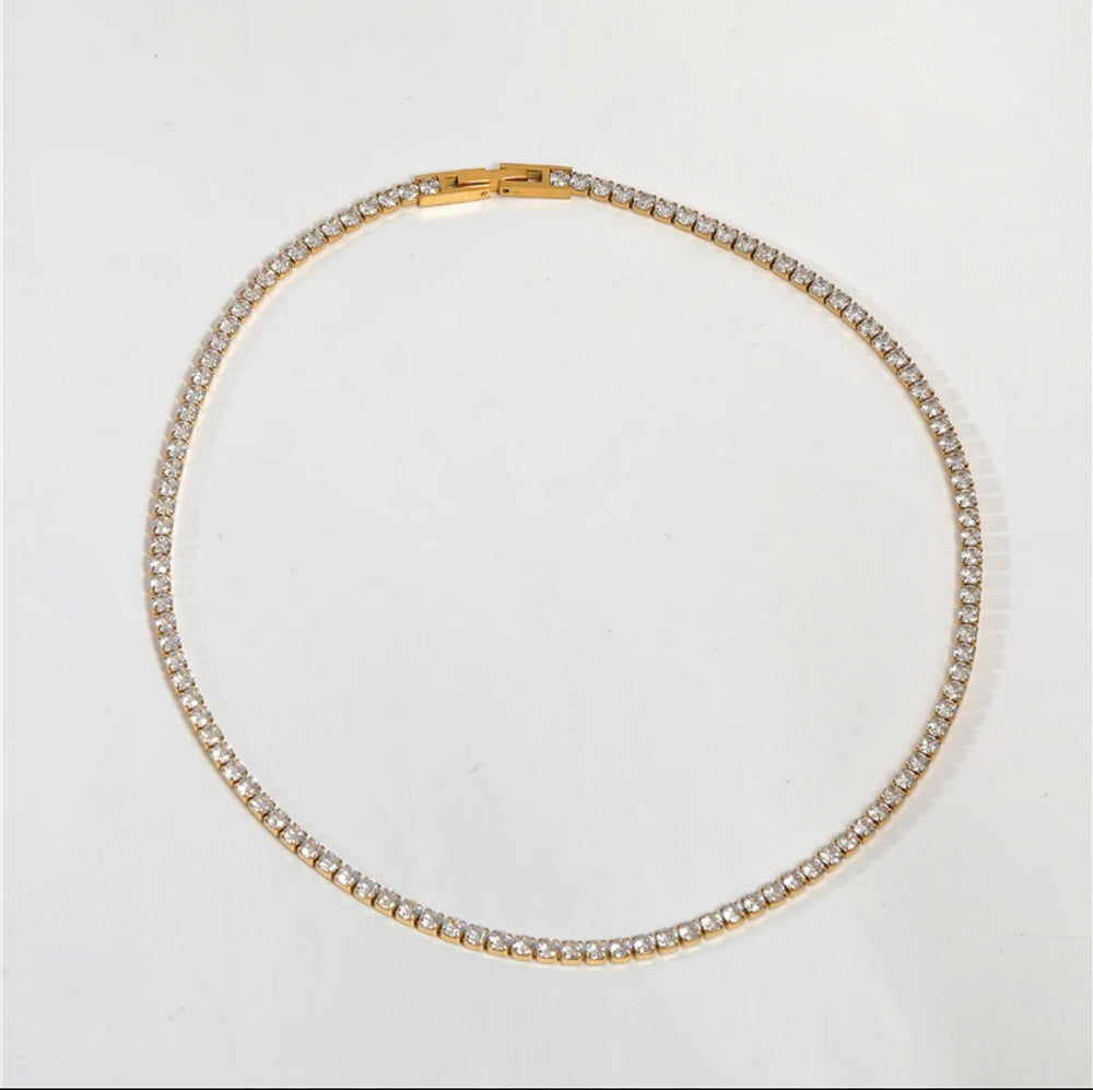 a gold and diamond necklace on a white background