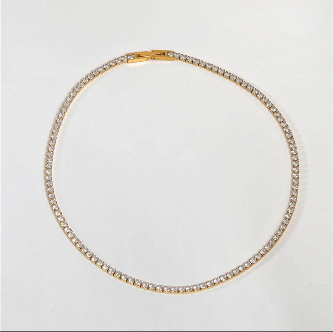 a gold and diamond necklace on a white background