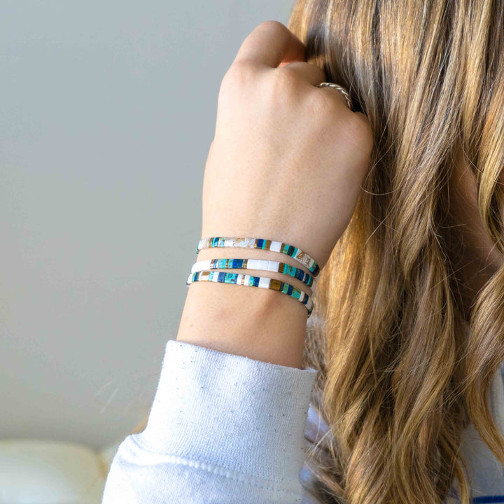 a woman wearing a bracelet and a white shirt