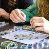 two people working on a craft project on a table