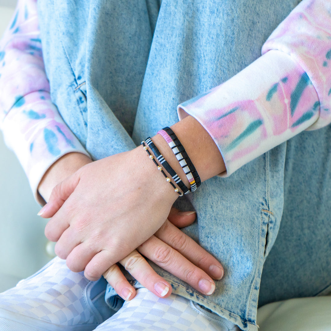 a person sitting on a couch holding their hands together