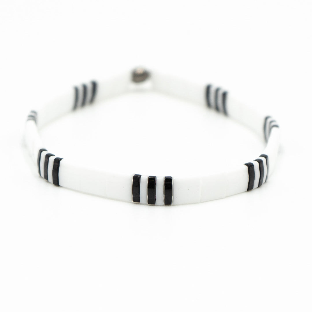 a white bracelet with black stripes on a white background