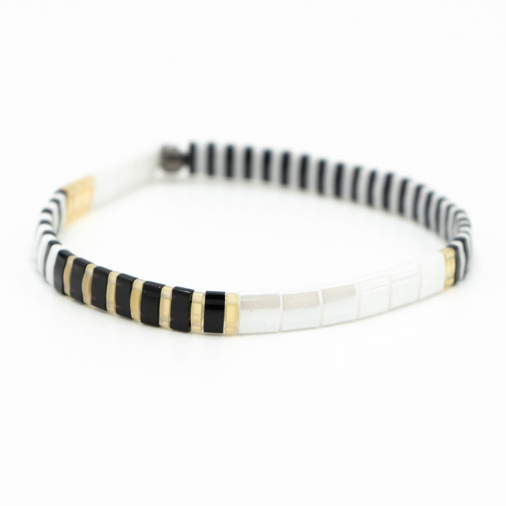 a black and white bracelet with gold accents