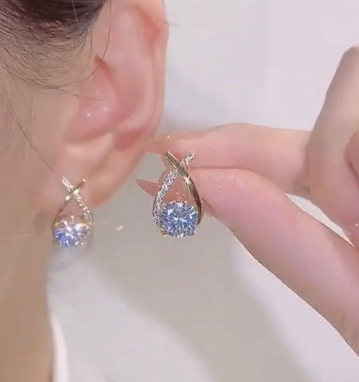 a close up of a person holding a pair of earrings