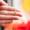 a person is holding a tiny gold necklace